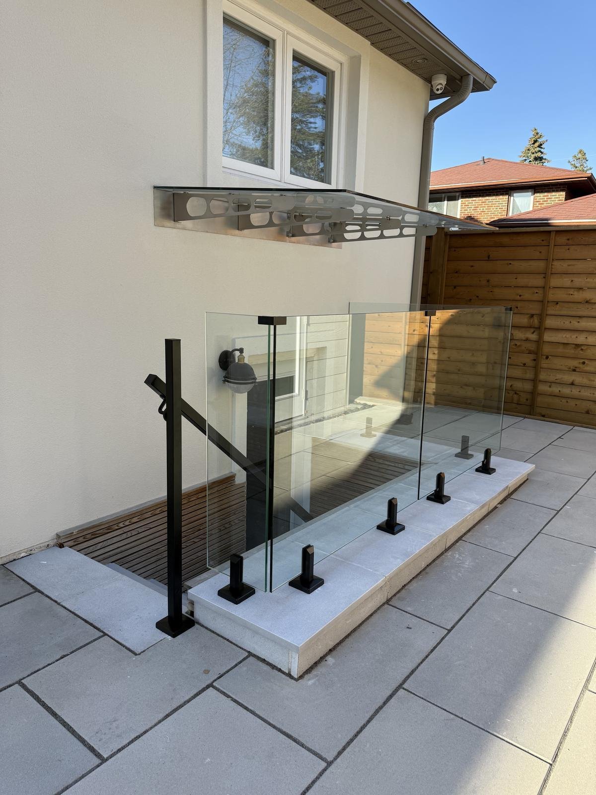 Glass railing with black posts on residential patio steps